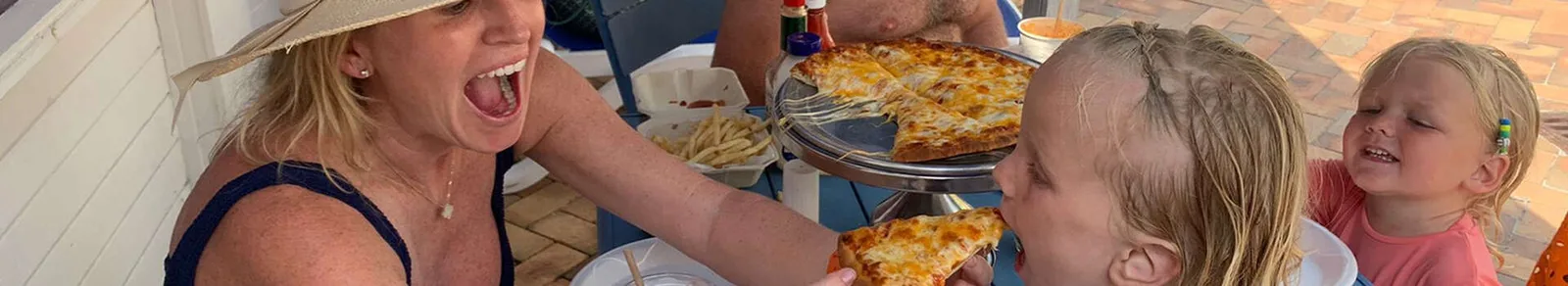 A family sharing a cheese pizza poolside at Hemingway’s, which also runs Bimini Pizza, at Bimini Big Game Club