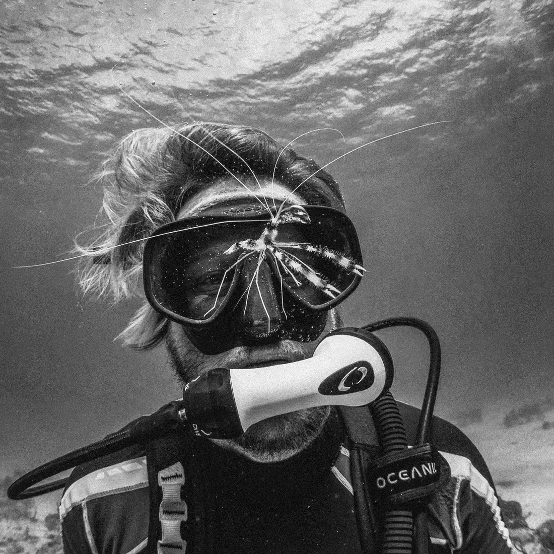 Close-up black-and-white portrait of a scuba diver in a mask and regulator underwater at Neal Watson’s Bimini Scuba Center