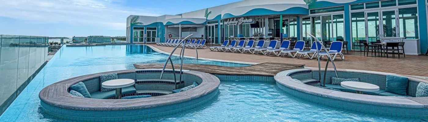 The Monkey Business rooftop pool and swim-up bar at Resorts World Bimini, with lounge chairs overlooking the water